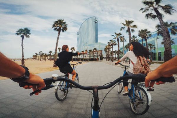 POV bicycle riding with friends at Barceloneta beach in Barcelona, Spain